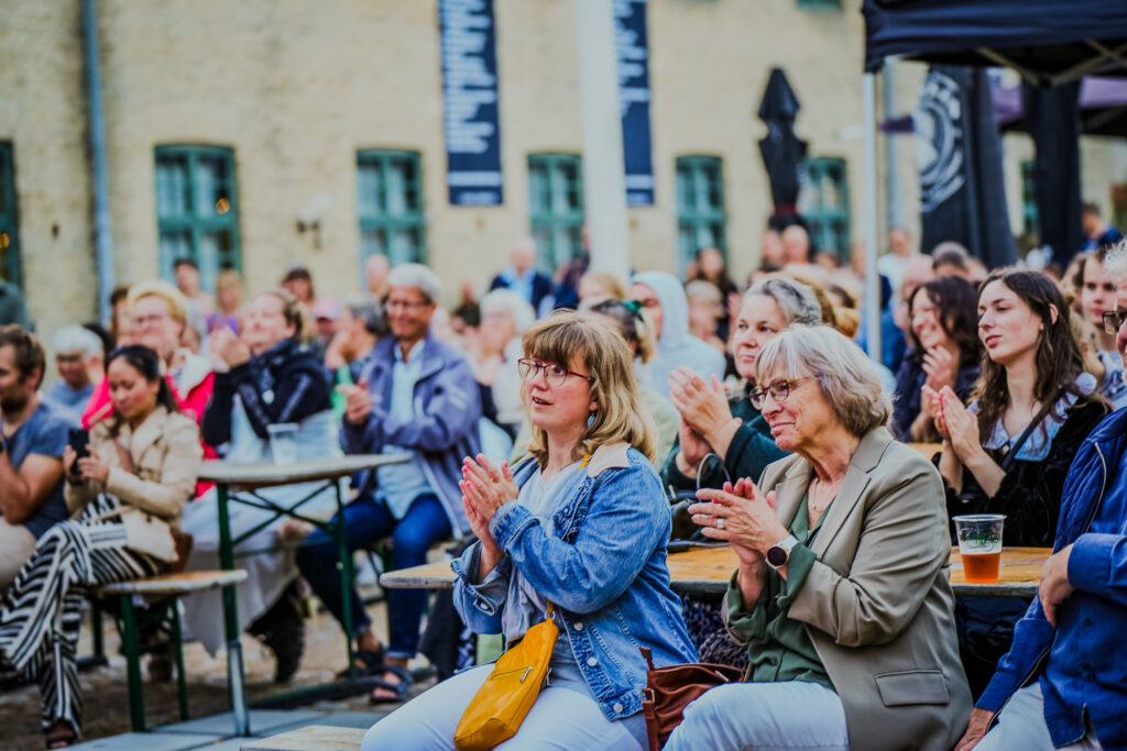 Publikum lytter med til de gratis arrangementer til Musicalens Folkemøde 2025. Foto: Musicalens Folkemøde
