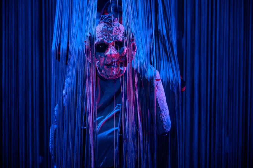 En ulækker og slibrig zombie bryder ud af bagtæppet, String Curtain. Dukker og scenografi af Annika Nilsson. Foto: Søren Meisner.